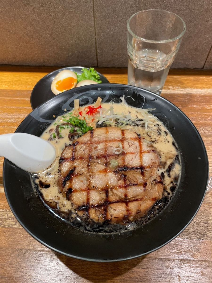 A bowl of tonkotsu ramen with grilled chashu and a soft egg